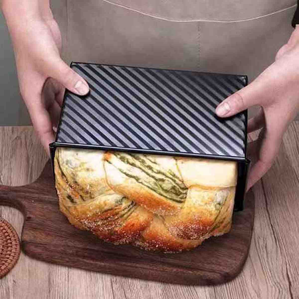 Démoulage facile d'une brioche tressée cuite dans le moule à pain de mie PâtissiPro, démontrant l'efficacité du revêtement antiadhésif