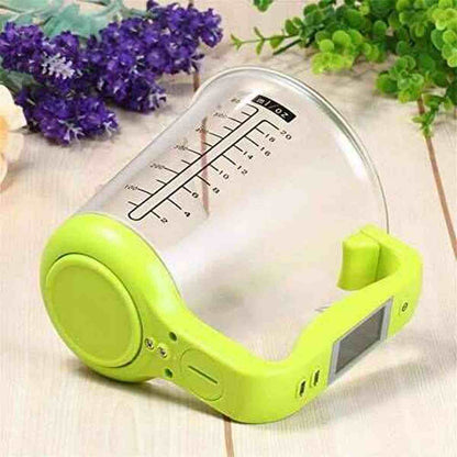 Vue de profil de la balance de cuisine électronique verte montrant la poignée ergonomique avec écran LCD intégré et la tasse mesureuse amovible.