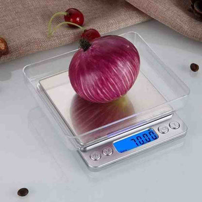 Oignon rouge pesé dans un plateau amovible transparent sur la balance de cuisine électronique en inox, affichant une mesure précise.