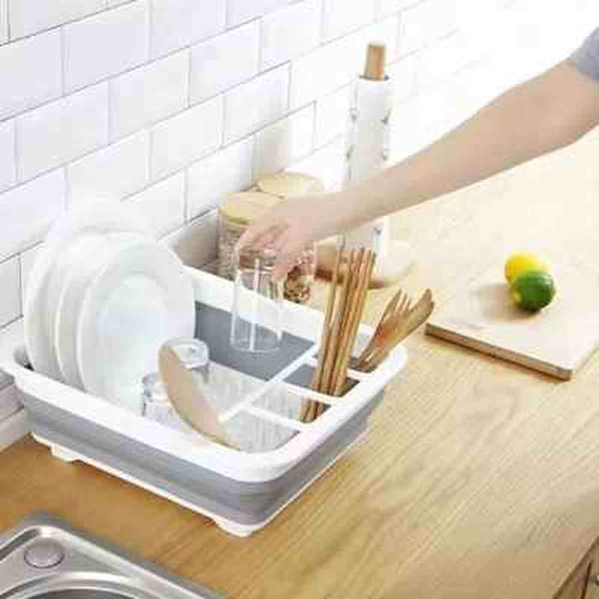Égouttoir à vaisselle pliable Compact Kitchen blanc utilisé pour faire sécher des verres et des baguettes sur un plan de travail de cuisine.