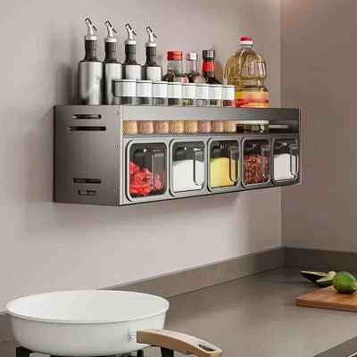 Égouttoir à épices mural gris avec rangements pour bouteilles d'huile et tiroirs à épices transparents installé en cuisine.