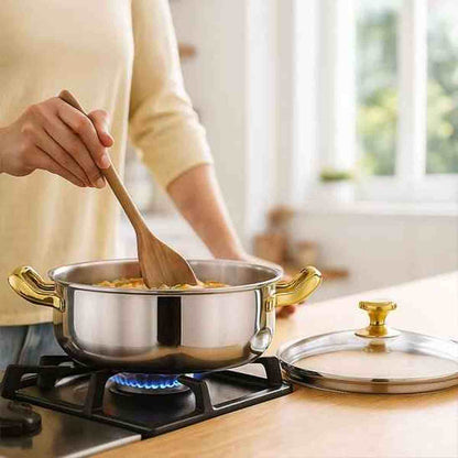 Utilisation du faitout en fonte émaillée sur une gazinière, montrant la spatule en bois remuant un plat pour illustrer la profondeur de la cuve.
