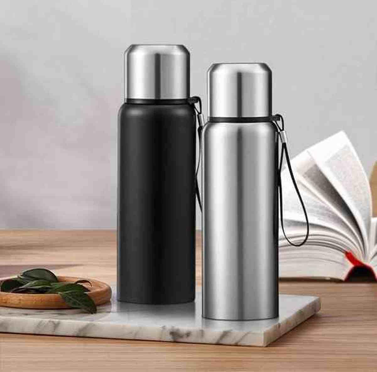 Gourde isotherme premium noire et argent tenue à la main, design élégant pour le quotidien.