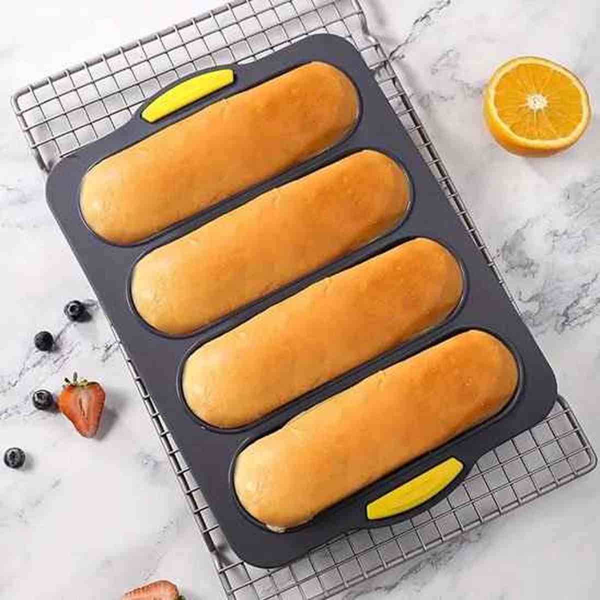 Moule à pain en silicone perforé gris avec 4 cavités, idéal pour une cuisson croustillante et un démoulage facile des baguettes et pains maison.