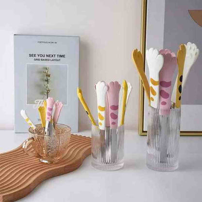 Présentation de la collection de pinces de cuisine en forme de pattes de chat dans des tons rose, jaune et blanc, parfaites pour une décoration de cuisine moderne.