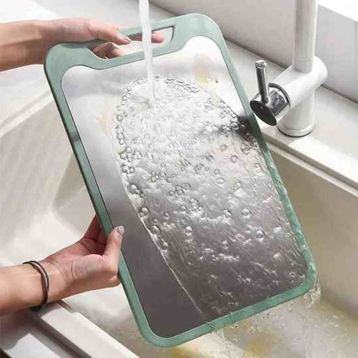 Planche à découper robuste en plastique haute qualité passée sous l'eau pour un nettoyage facile.