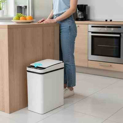 Poubelle de cuisine blanche 50L avec couvercle automatique à capteur, placée à côté d'un îlot central en bois pour un usage hygiénique