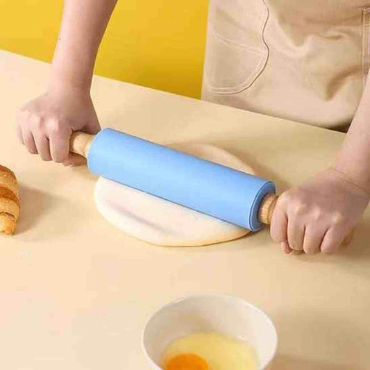 Rouleau à pâtisserie professionnel en silicone bleu antiadhésif Artisan Pro étalant une pâte sur un plan de travail.